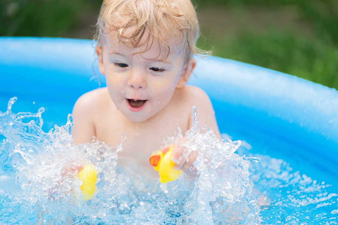 Niño pequeño aprendiendo a cepillarse los dientes con ayuda de un adulto en el baño